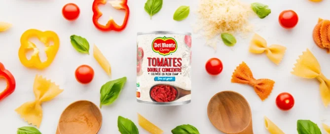 Boîte de double concentré de tomates Del Monte entourée de pâtes et ingrédients frais.