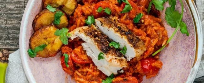 Rondelles de plantain jaune frites servies avec riz en sauce tomate et poulet grillé, plantain mûr légèrement sucré